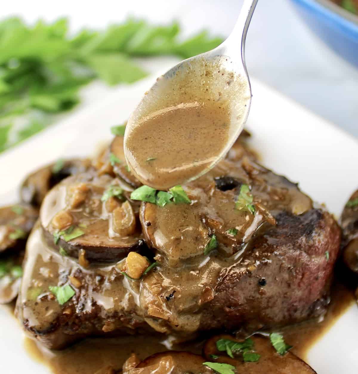 Filet Mignon with Mushroom Sauce with sauce being spooned over top