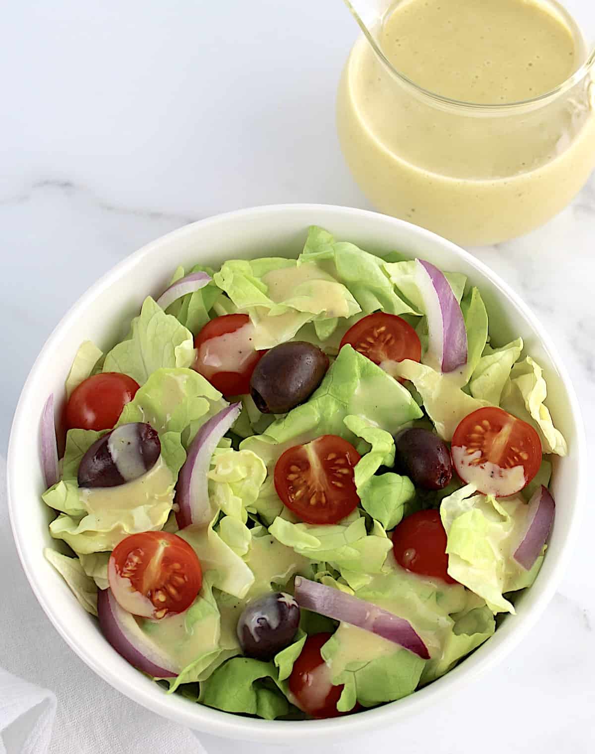salad with honey mustard dressing on top and in background