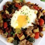 closeup of runny egg over Italian Sausage and Peppers Hash