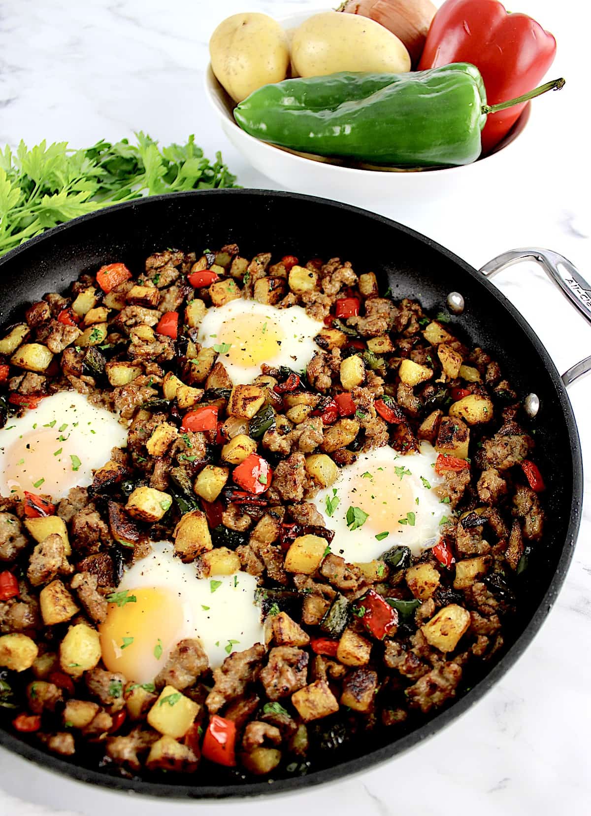 Italian Sausage and Peppers Hash with 4 eggs in skillet