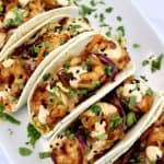 overhead view of Asian Shrimp Tacos lined up on white plate