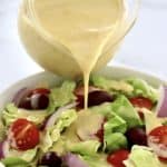 Honey Mustard Dressing being poured over salad