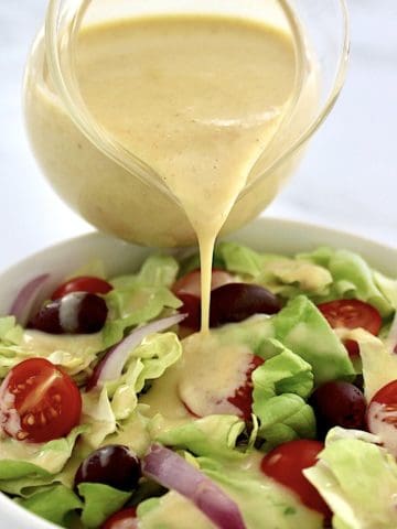 Honey Mustard Dressing being poured over salad