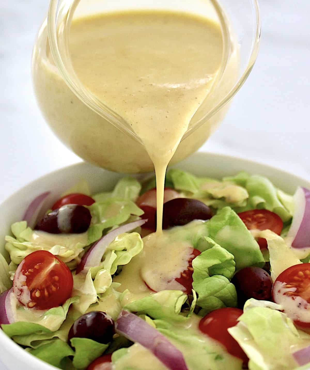 Honey Mustard Dressing being poured over salad