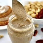Pecan Cashew Nut Butter dripped off spoon over glass jar