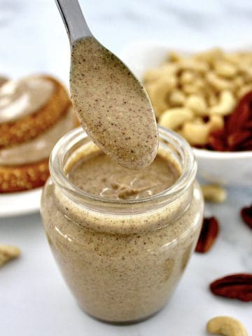 Pecan Cashew Nut Butter dripped off spoon over glass jar