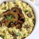 closeup of Mushroom Risotto in white bowl with thyme on top