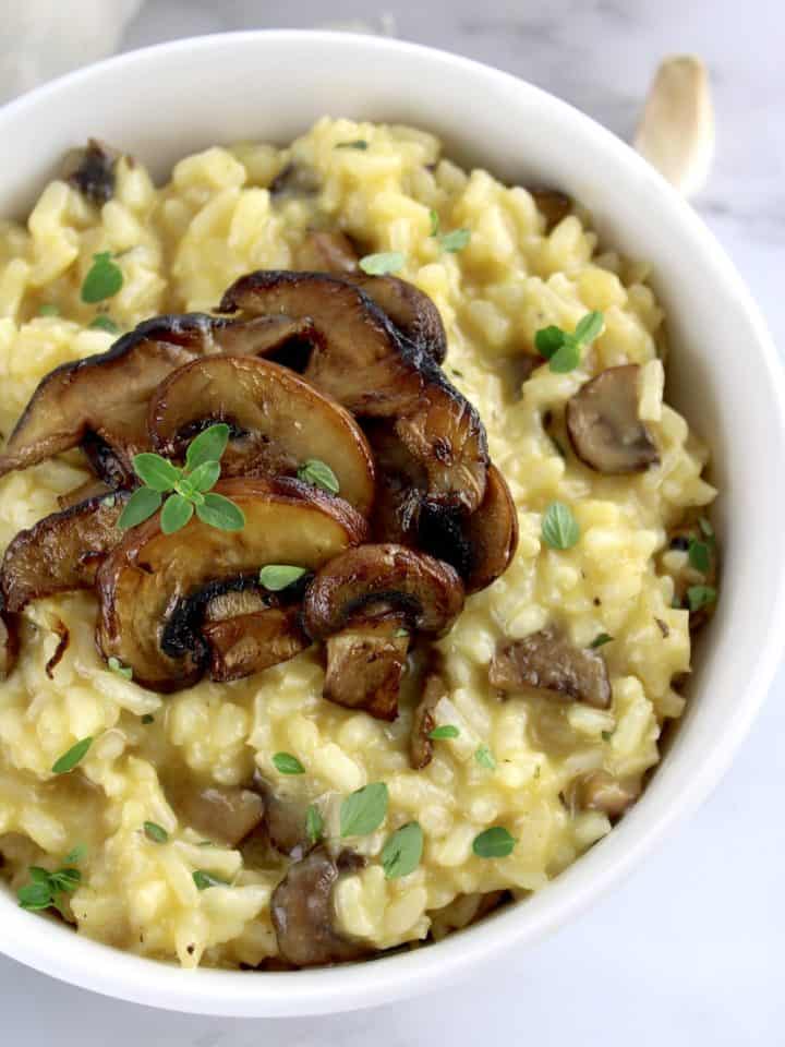 closeup of Mushroom Risotto in white bowl with thyme on top