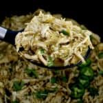 Slow Cooker Salsa Verde Chicken in black serving spoon over slow cooker