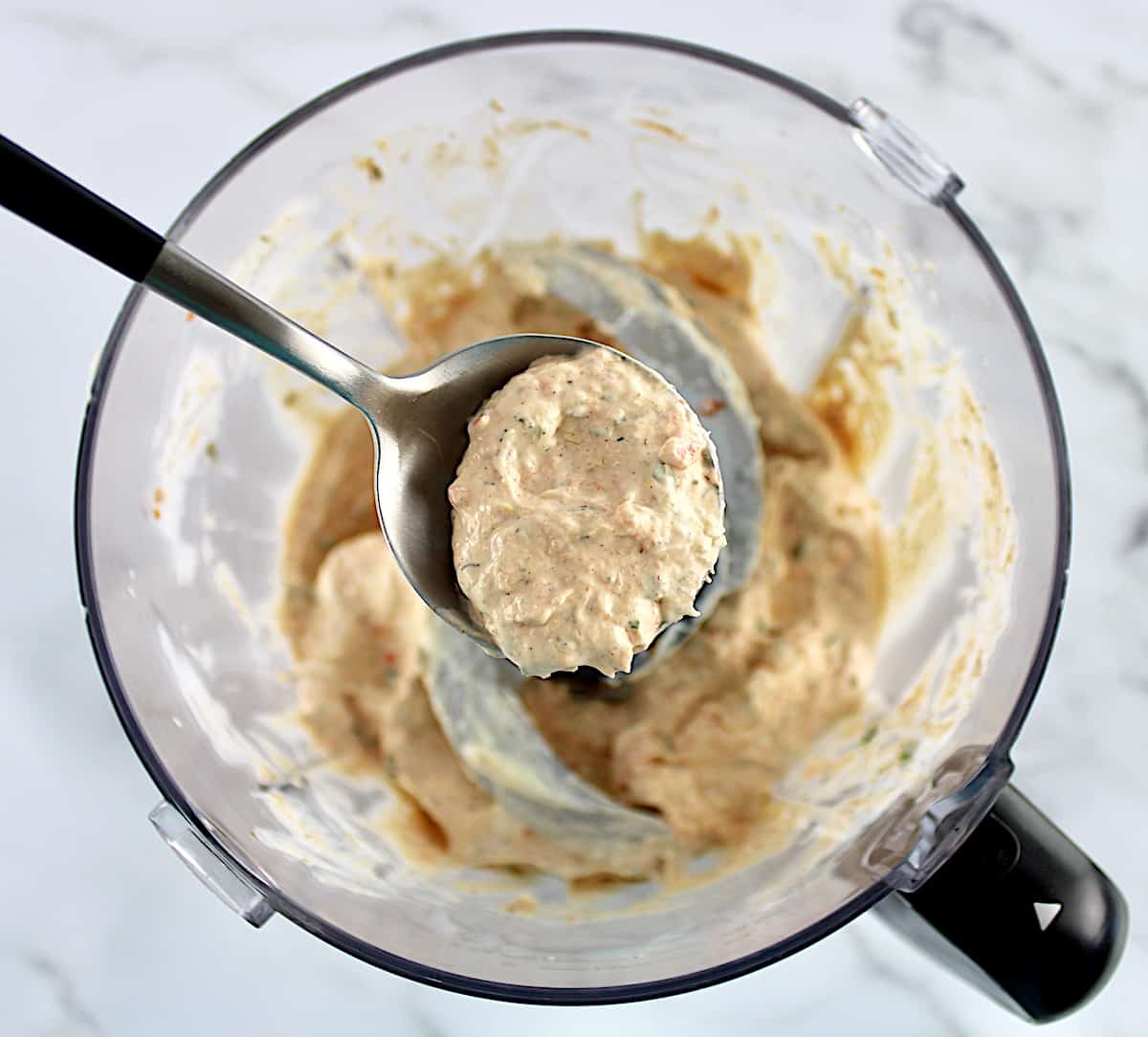 Smoked Salmon Dip in food processor with spoon holding up some