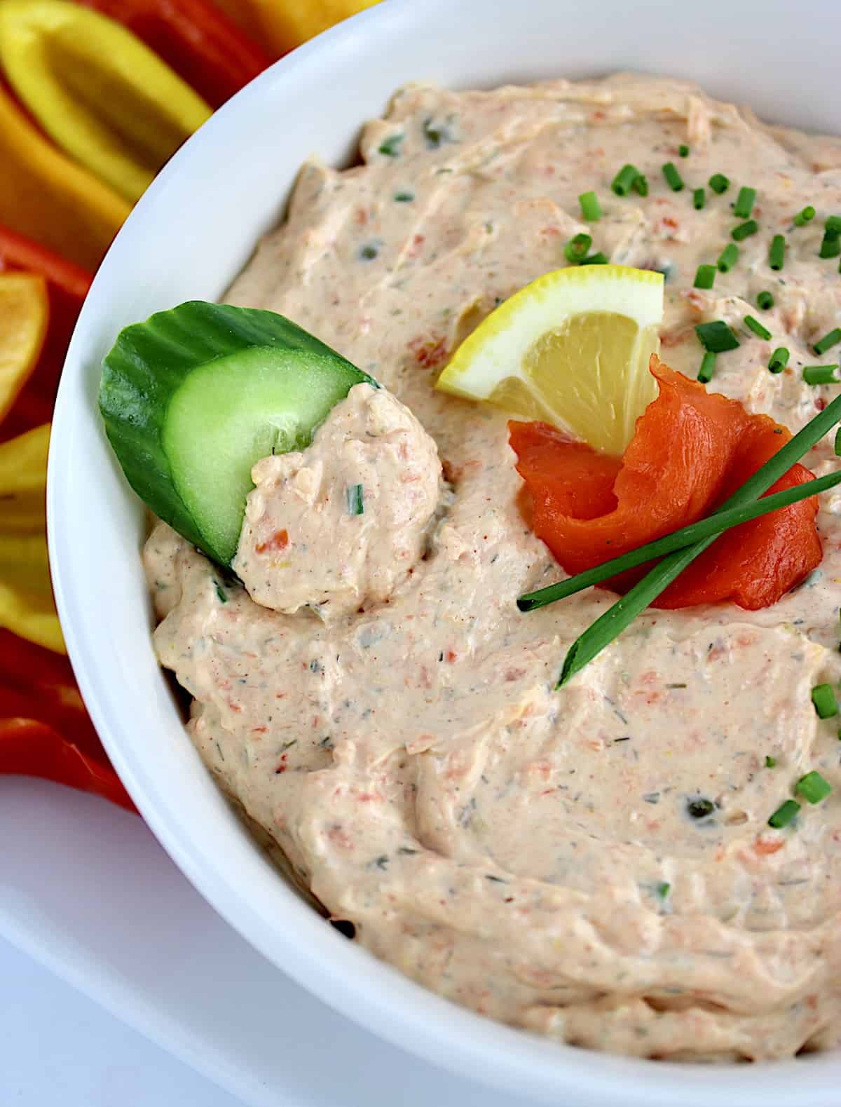 Smoked Salmon Dip in white bowl with cucumber slice in the dip