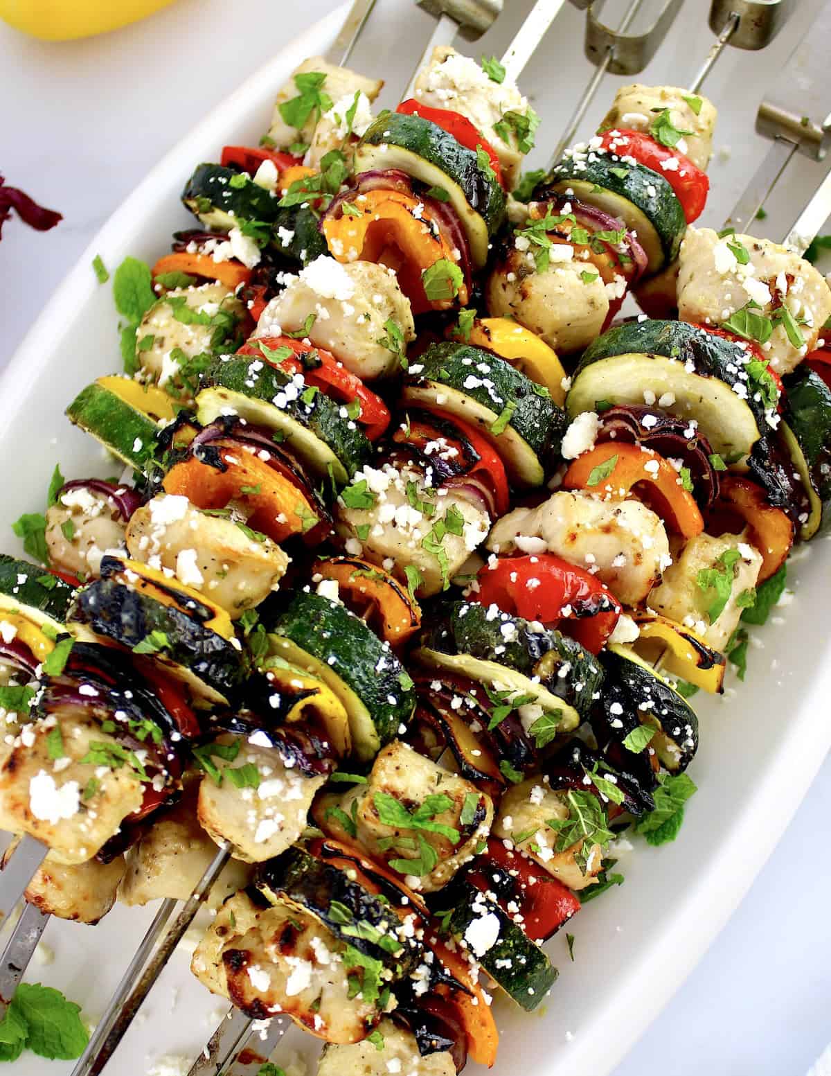 overhead view of Greek Chicken Kebabs on white oval plate