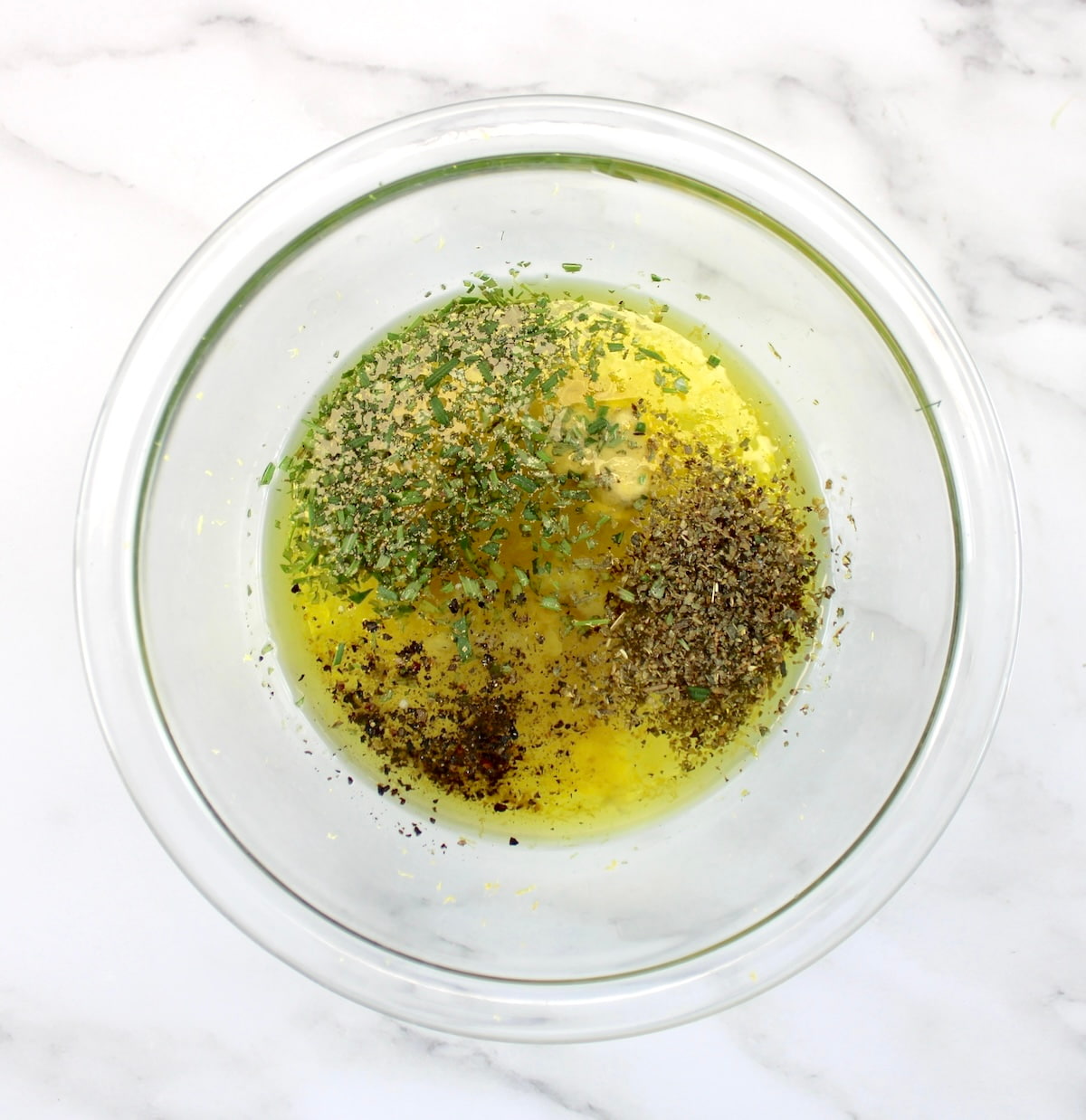 Greek Lemon Chicken marinade ingredients in glass bowl unmixed