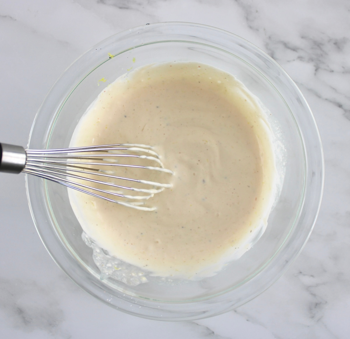 Crab Salad Stuffed Avocados dressing in glass bowl with whisk