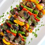 Grilled Beef Kebabs on white plate with chopped parsley