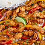 Sheet Pan Chicken Fajitas with lime wedge and tortillas in foil