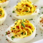 closeup of Deviled Eggs with Tajin on white plate