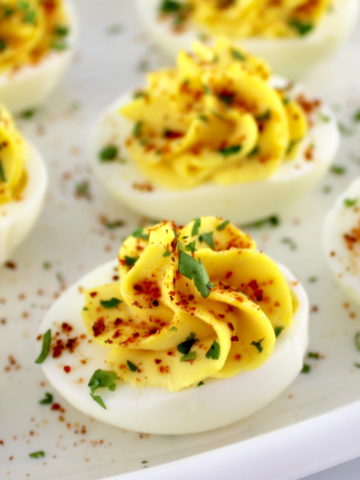 closeup of Deviled Eggs with Tajin on white plate