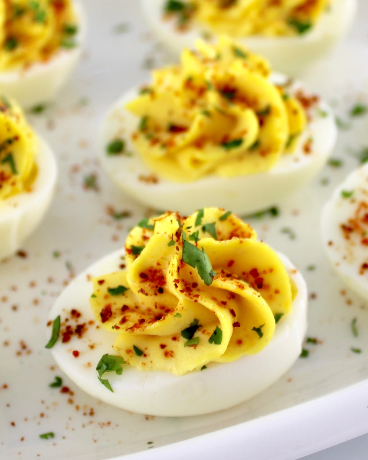 closeup of Deviled Eggs with Tajin on white plate