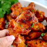 holding up Hot Honey Chicken Wing with more in background