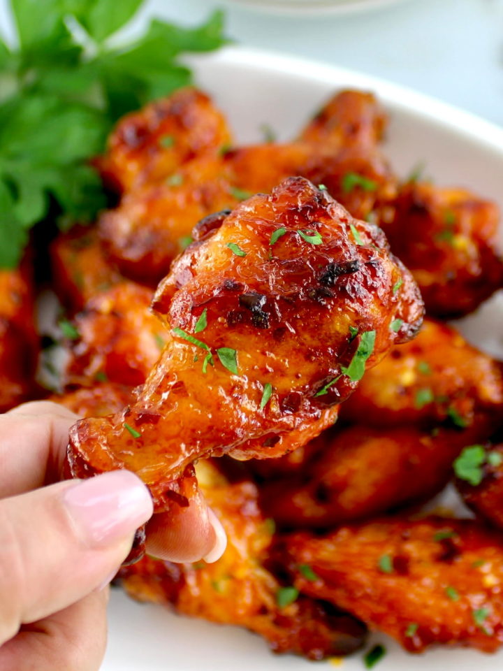 holding up Hot Honey Chicken Wing with more in background