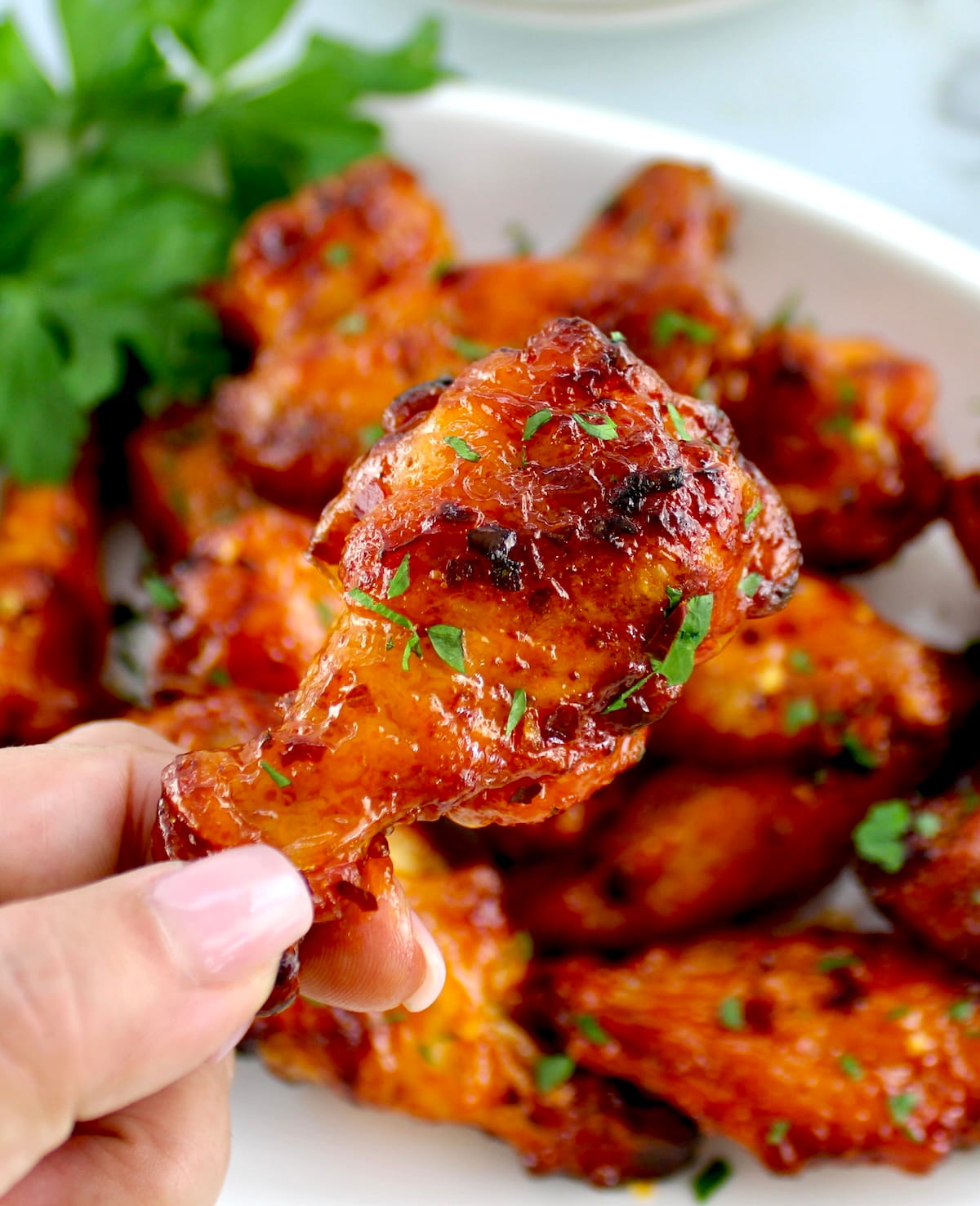 holding up Hot Honey Chicken Wing with more in background