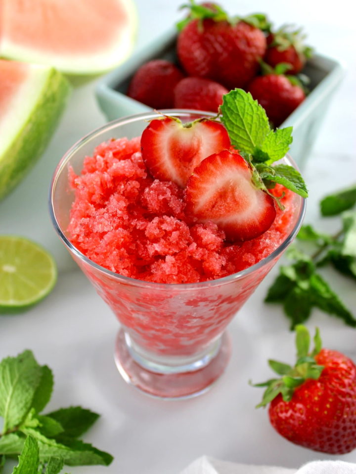 Strawberry Watermelon Granita in glass with strawberries, lime and mint in back