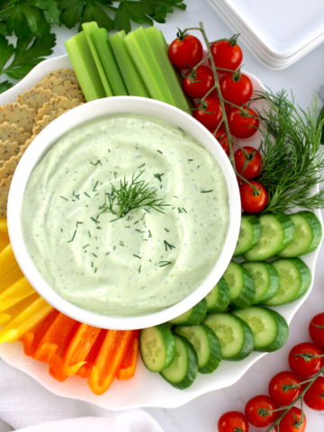overhead view of Whipped Cottage Cheese Dip in white bowl with fresh veggies and crackers around