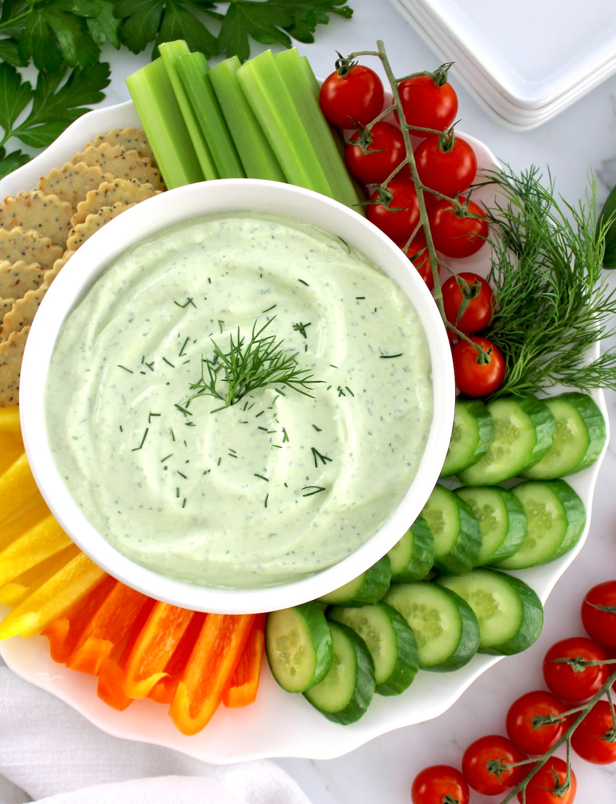 overhead view of Whipped Cottage Cheese Dip in white bowl with fresh veggies and crackers around