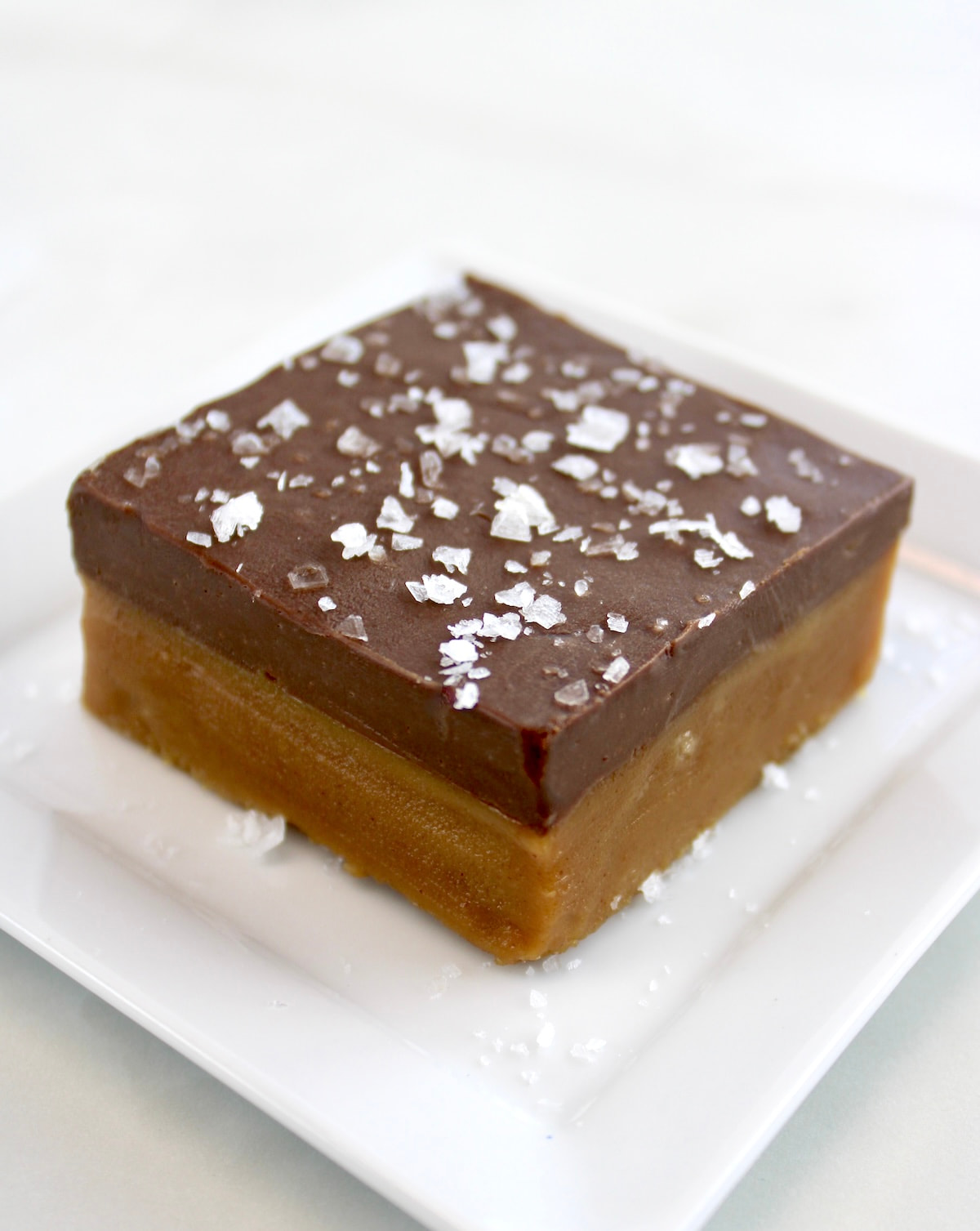 Chocolate Peanut Butter Bar on white plate with flaked salt on top