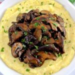 Creamy Polenta with Wild Mushrooms in white bowl with chopped parsley on top