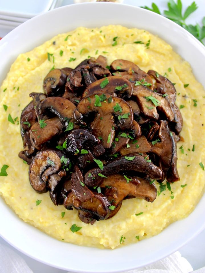 Creamy Polenta with Wild Mushrooms in white bowl with chopped parsley on top