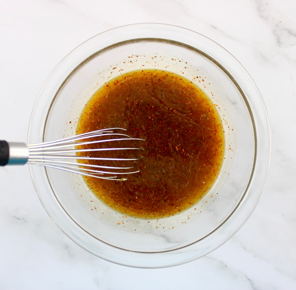 Grilled Tajin Chicken marinade ini glass bowl with whisk