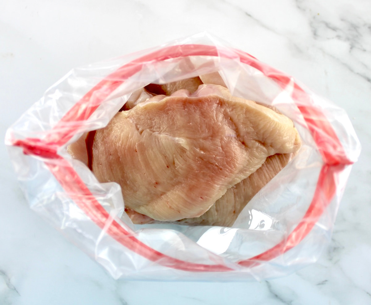 sliced raw chicken breasts in open food storage bag