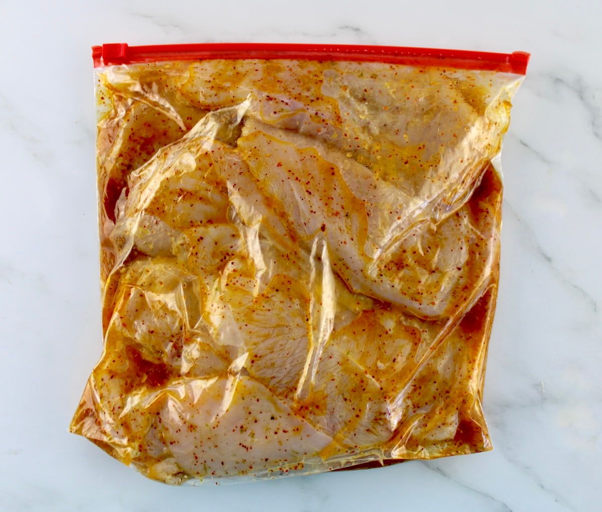 raw chicken marinating in food storage bag
