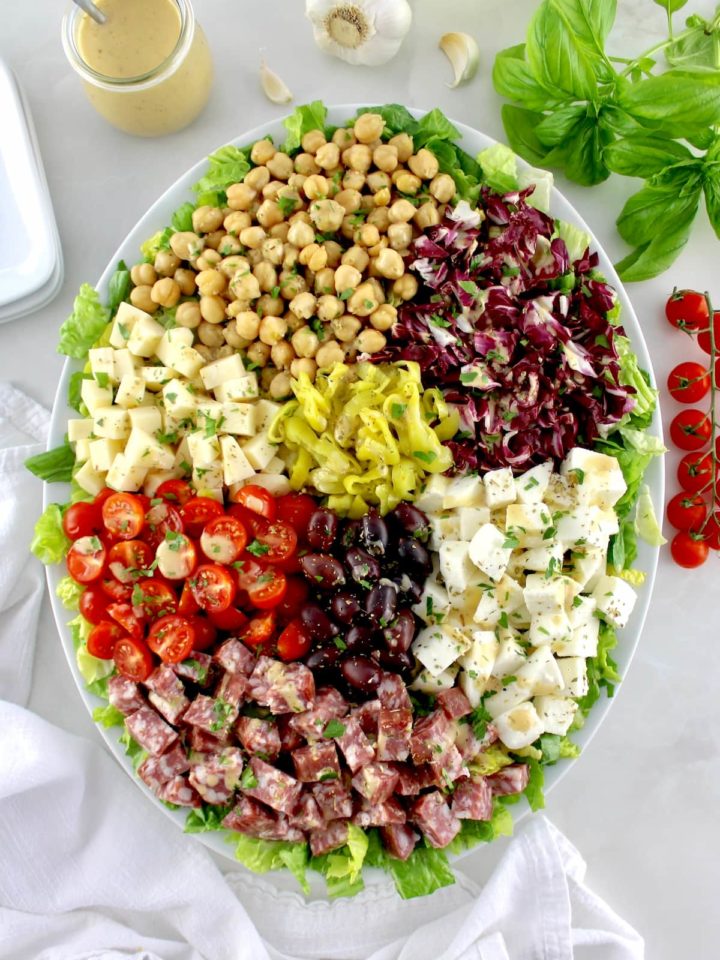 overhead view of Italian Chopped Salad on white oval platter with ingredients in sections