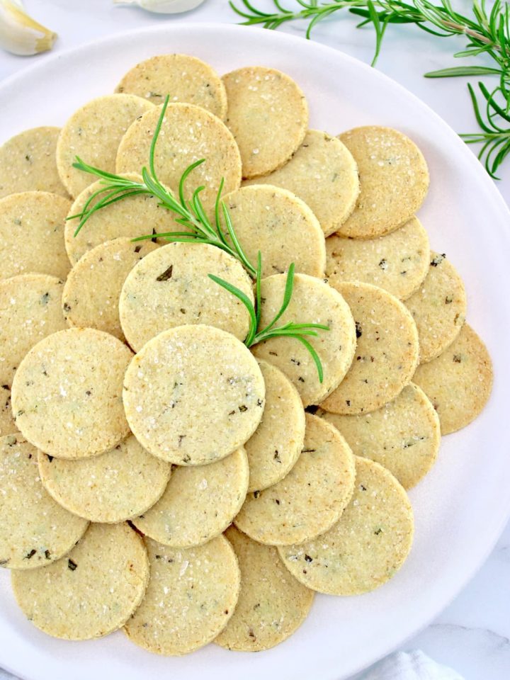 Rosemary Garlic Crackers on white plate with rosemary sprigs