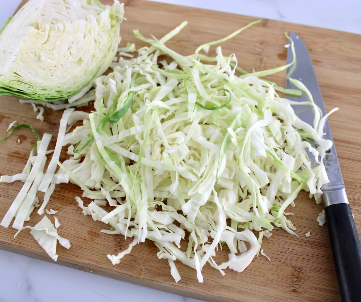 shredded green cabbage on cutting board