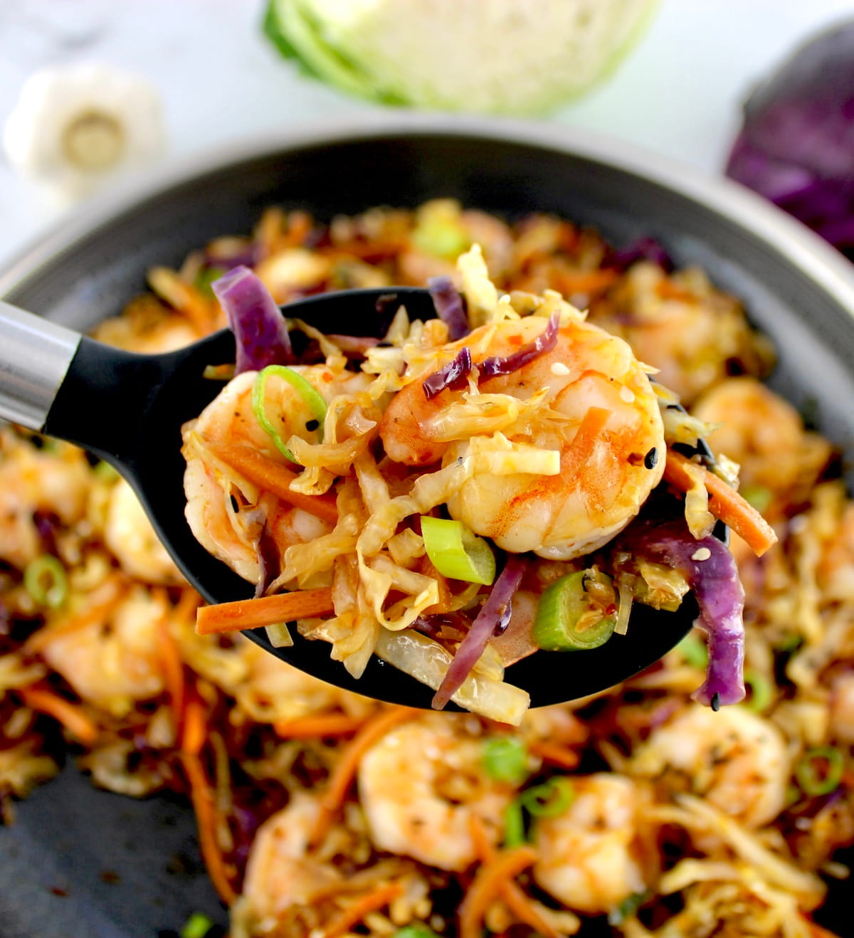 Shrimp Egg Roll in a Bowl in black serving spoon held up over skillet