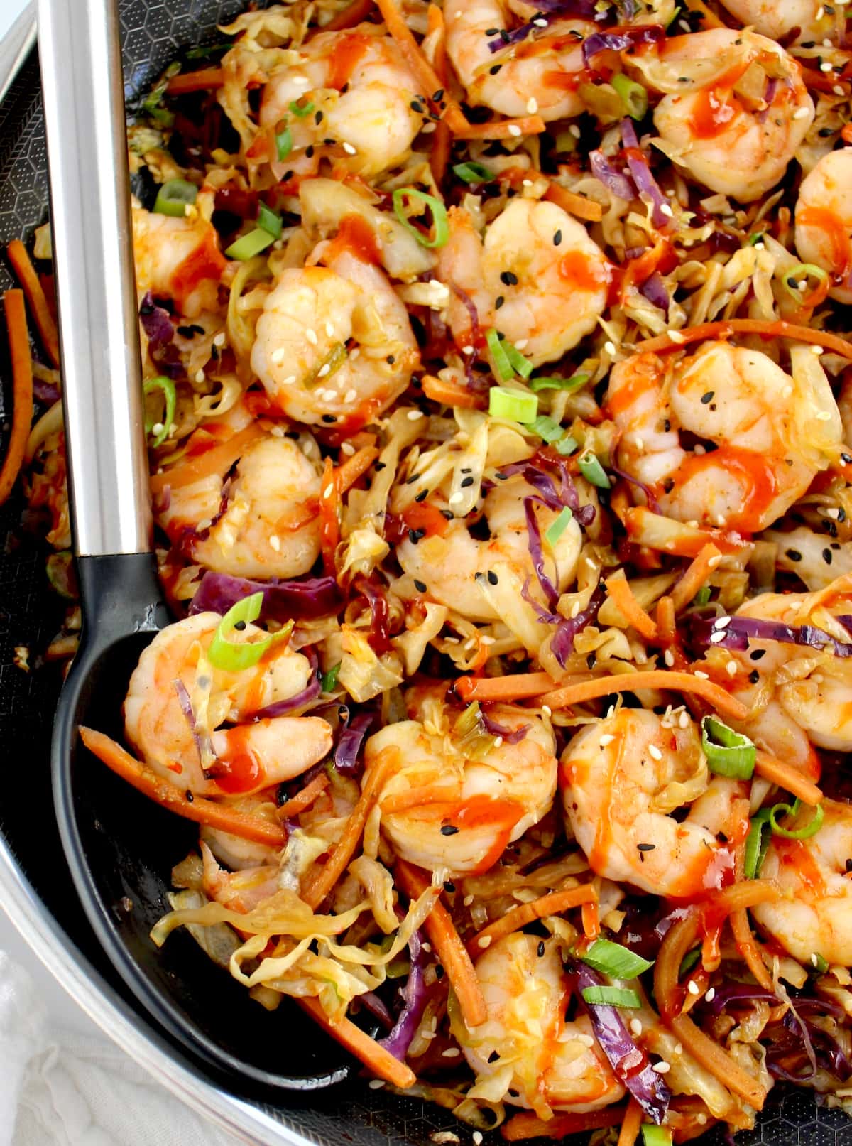 closeup of Shrimp Egg Roll in a Bowl in skillet with black serving spoon on side
