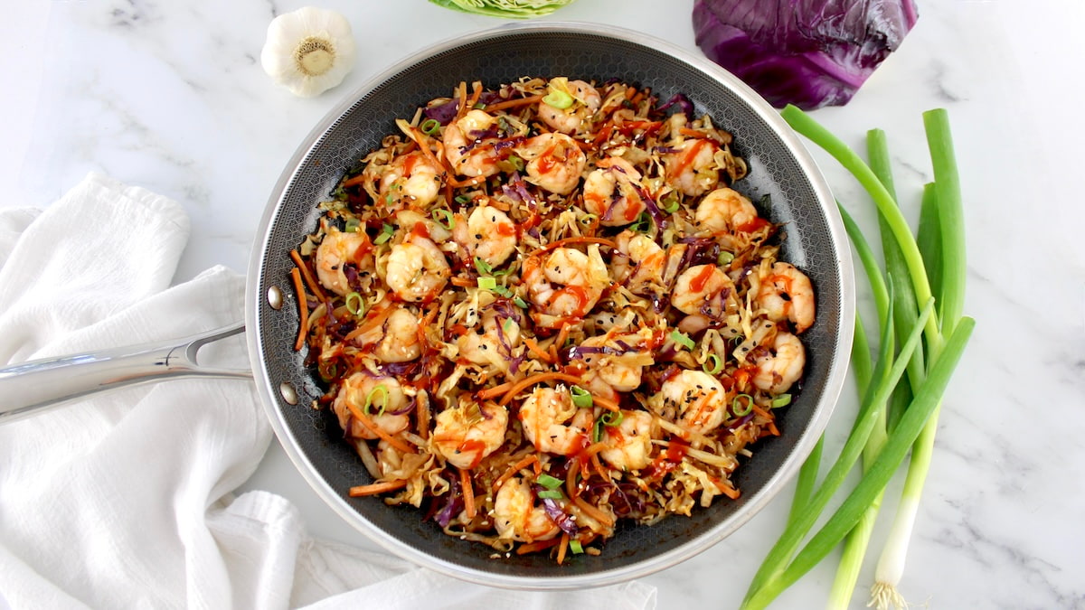 overhead view of Shrimp Egg Roll in a Bowl in skillet with scallions on side