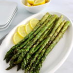 Easy Grilled Asparagus on white oval plate with lemon slices