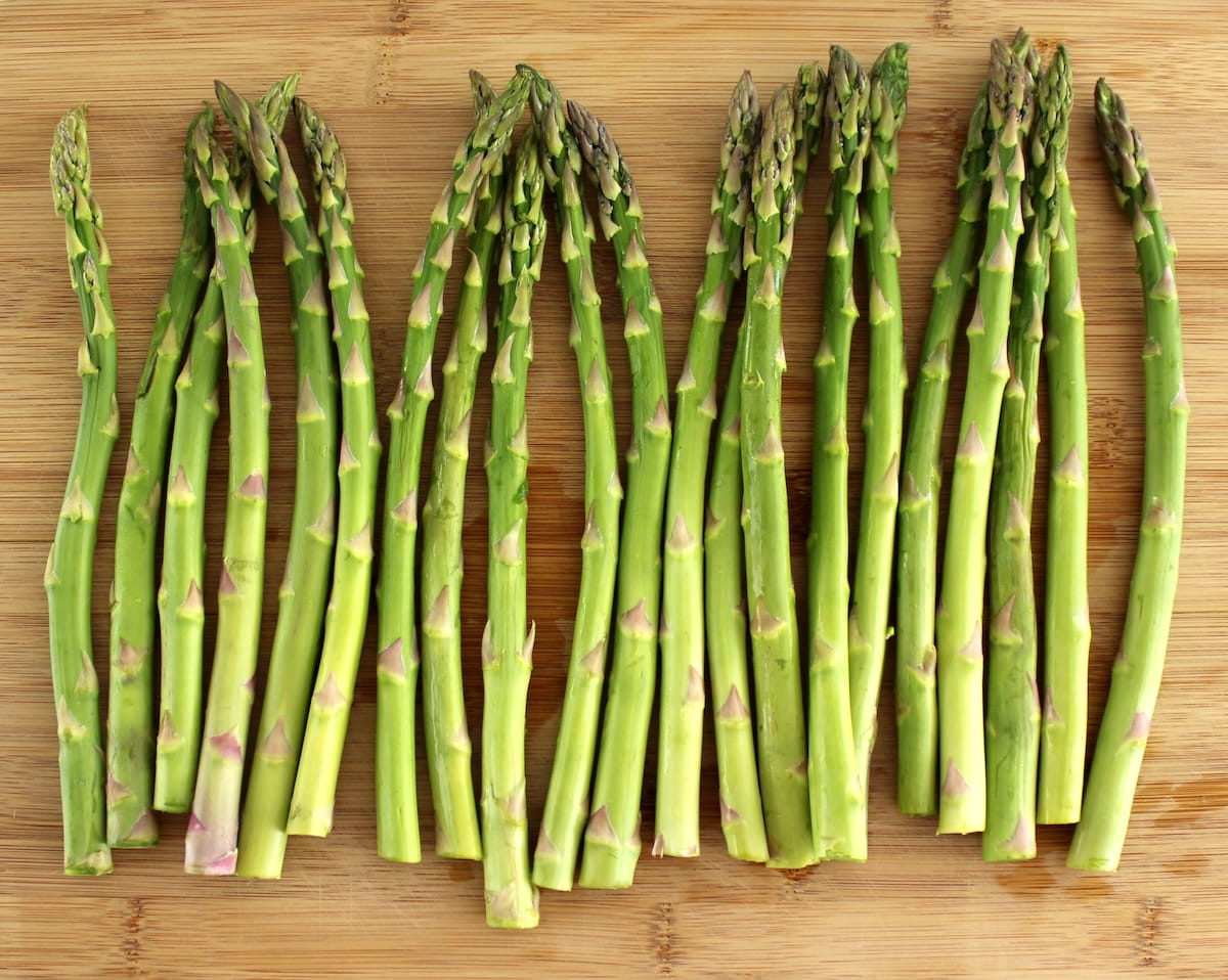 raw asparagus on cutting board