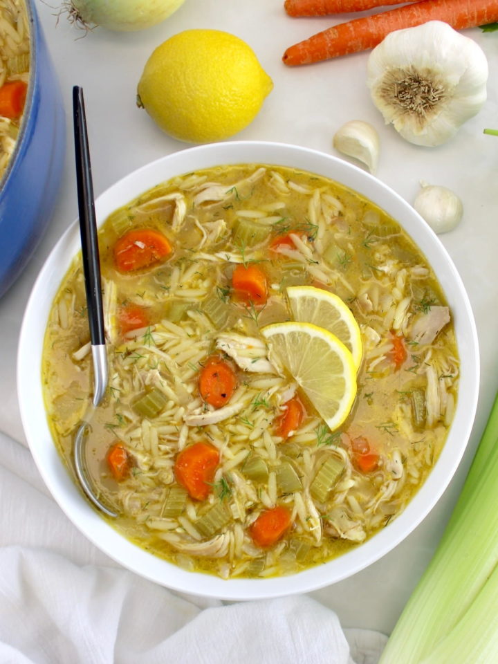Lemon Orzo Chicken Soup in white bowl with spoon on side