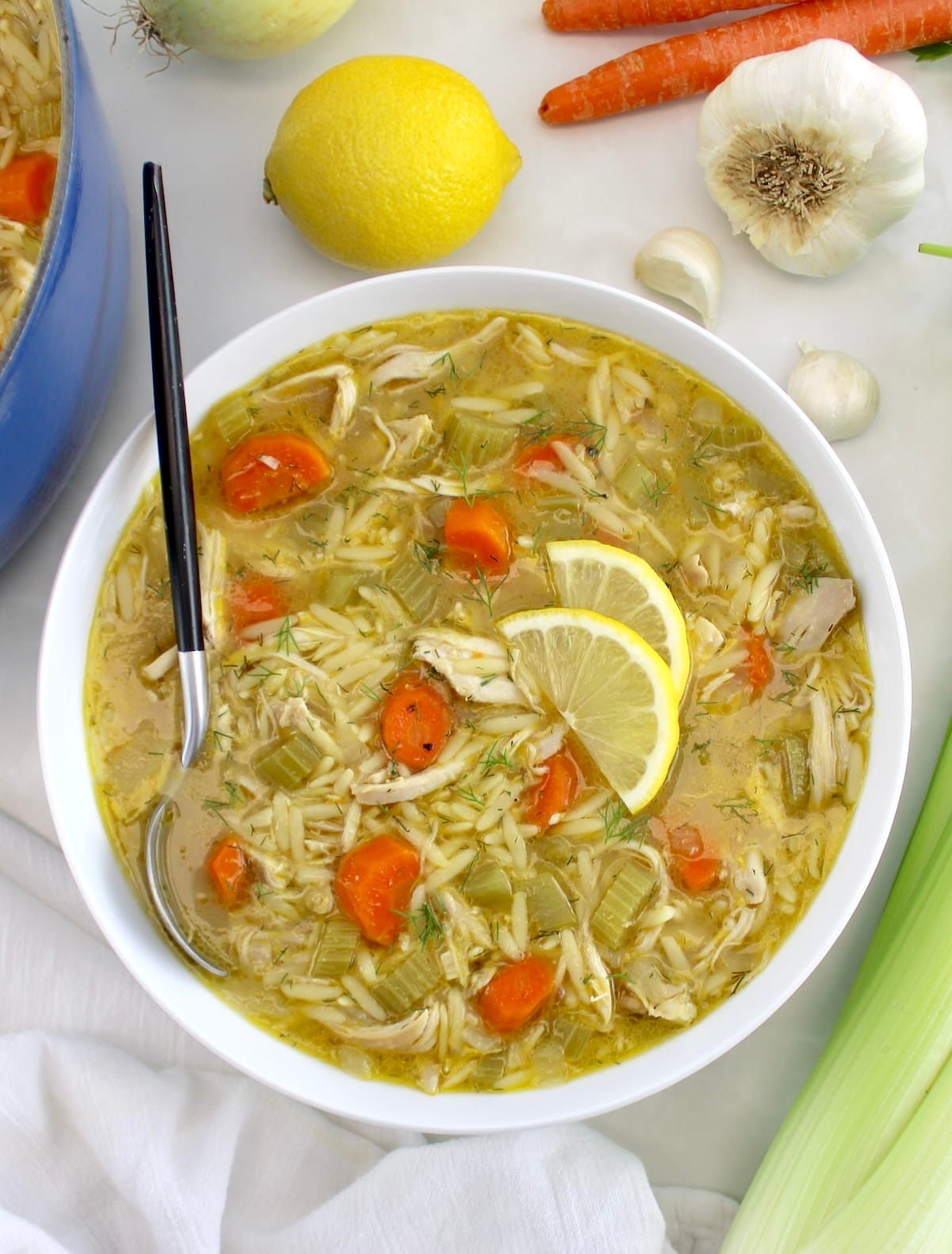 Lemon Orzo Chicken Soup in white bowl with spoon on side