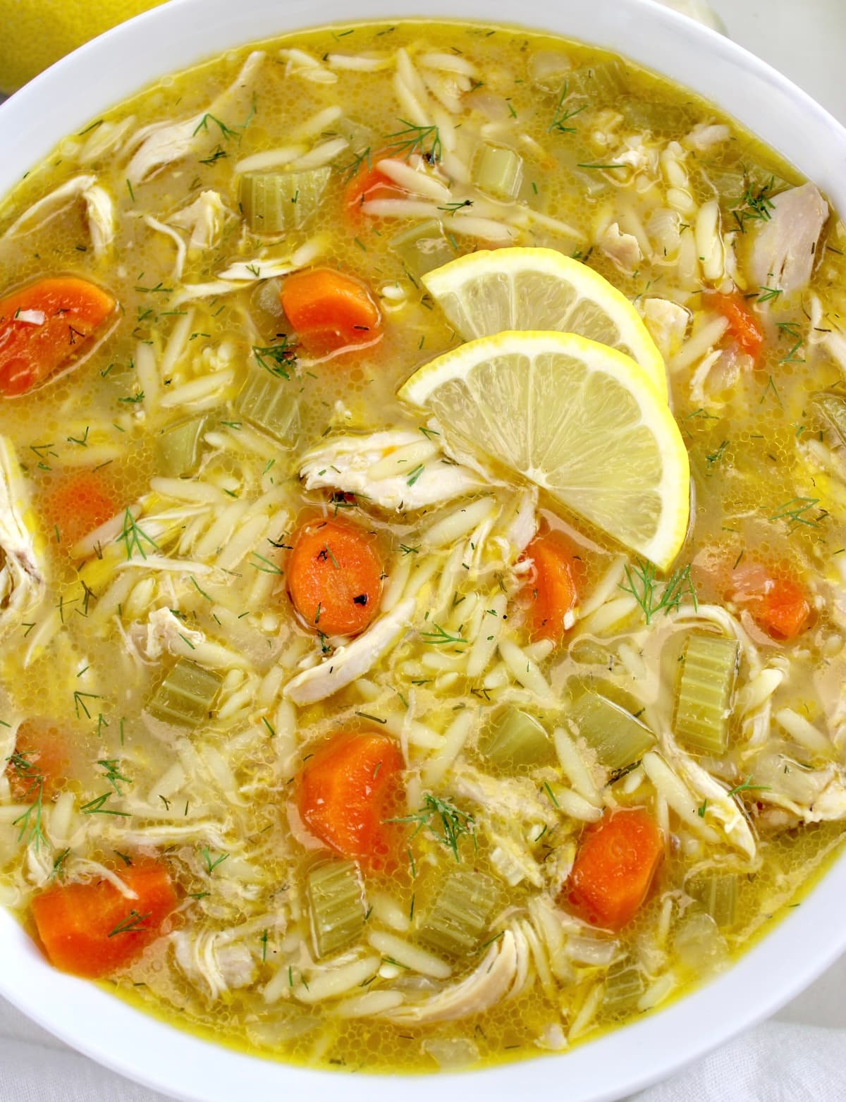 closeup of Lemon Orzo Chicken Soup in white bowl