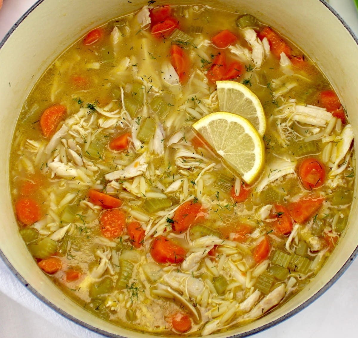 closeup view of Lemon Orzo Chicken Soup in dutch oven