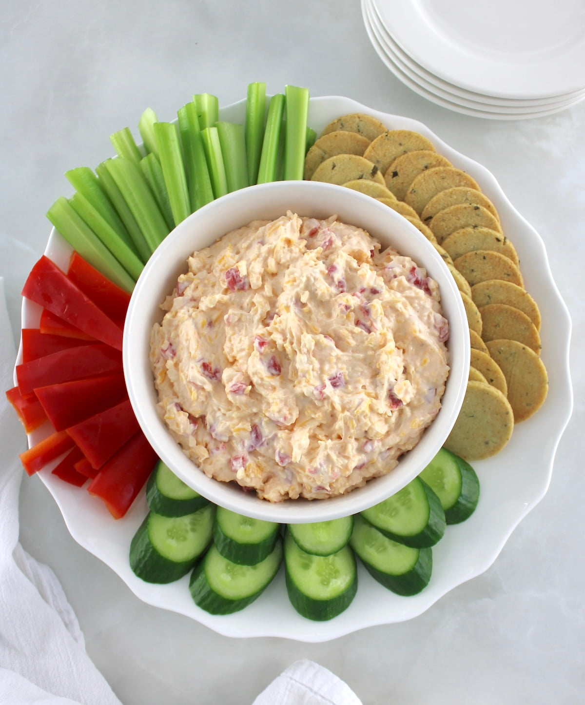overhead view of Pimento Cheese Spread in white bowl with veggies and crackers around