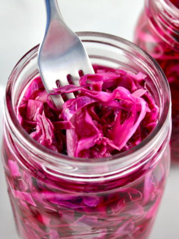 Easy Pickled Red Cabbage in open glass jar with fork stuck in