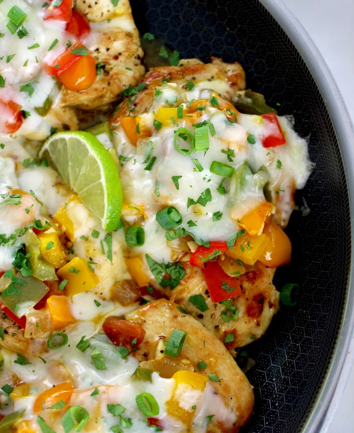 closeup of piece of Fiesta Chicken Skillet with lime slice and chopped cilantro